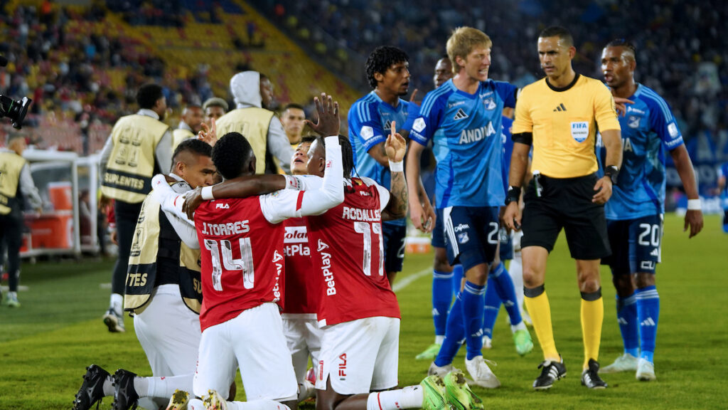 Jugadores de Santa Fe celebran un gol ante la mirada de Carlos Ortega. - Vizzor Image.